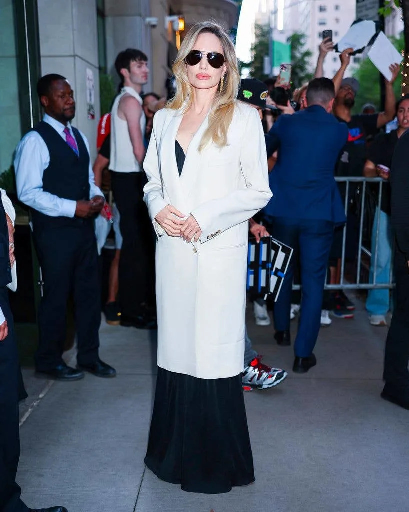 photo of angelina jolie wearing sunglasses and white coat nyc screening