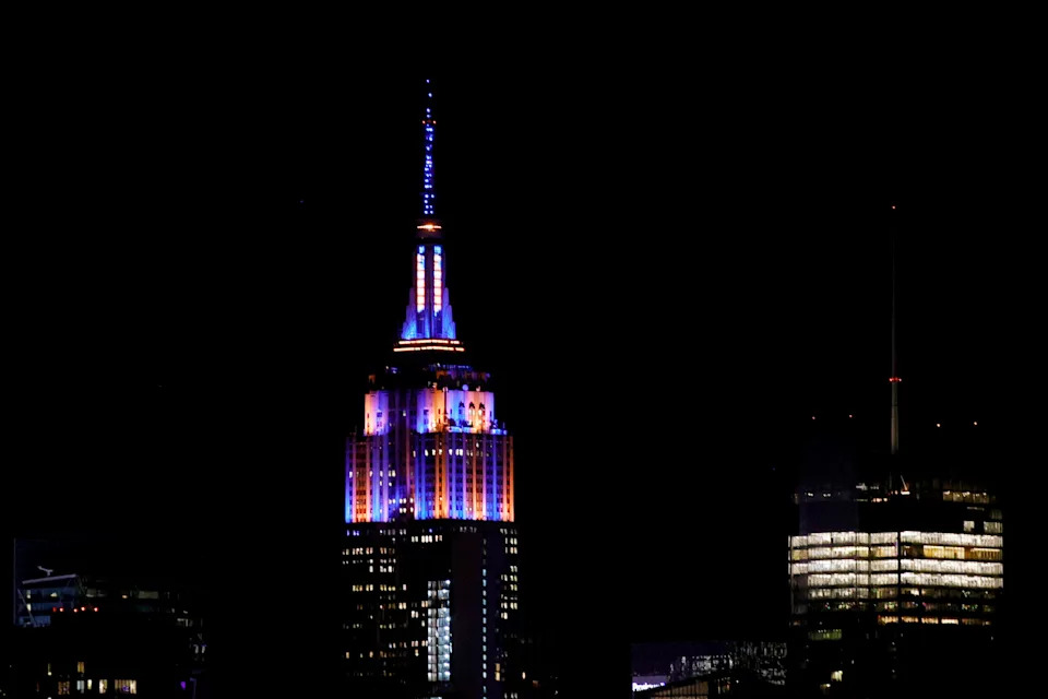 The Empire State Building is lit with the colors of New York Knicks.