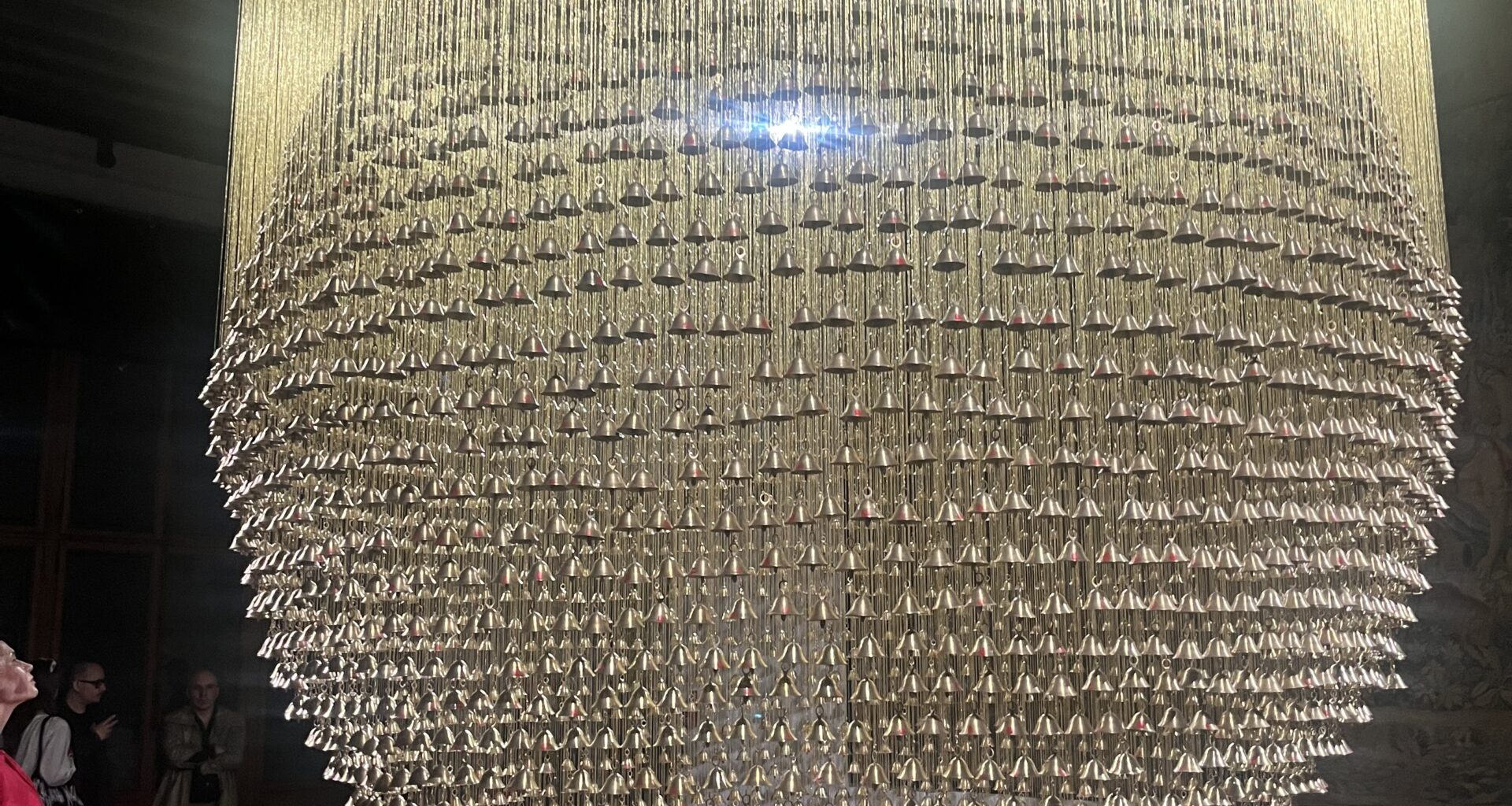 Ashfika Rahman, Than Para — No Land Without Us, 2025– . Installation with 4,849 temple bells (brass) bearing collected thumbprints from the community, golden silk threads, and metal frame. Courtesy the artist, in collaboration with the community of Than Para and the Chittagong Hill Tracts, Bangladesh. Photo: Monika Fabjinska.