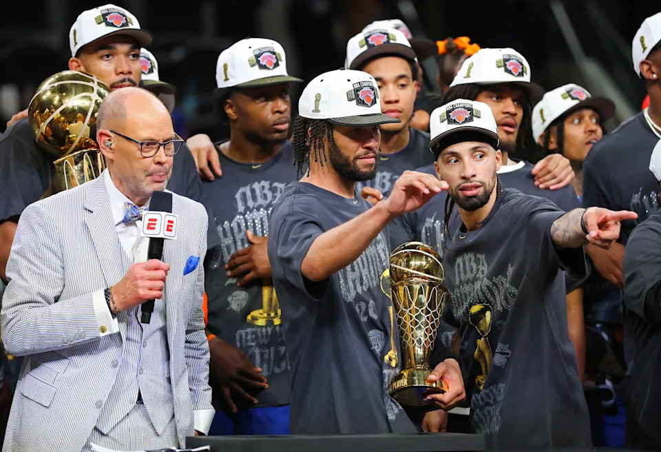 Jalen Brunson #11 of the New York Knicks celebrates with the Bill Russell NBA Finals Most Valuable Player Award trophy and Jose Alvarado #5.