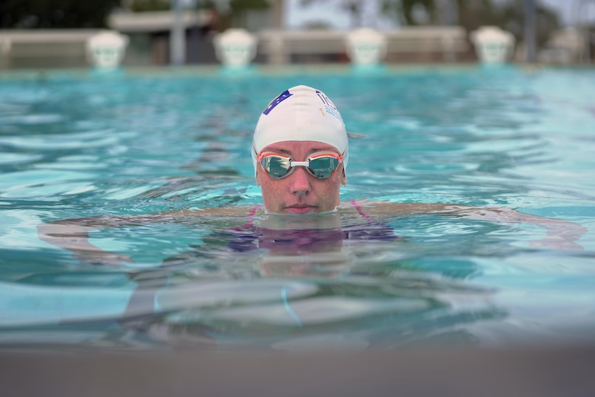 A woman with goggles on in the water.