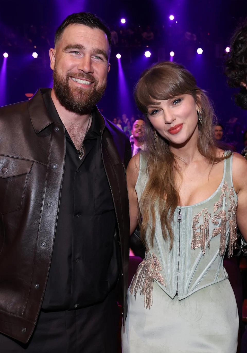 Travis Kelce and Taylor Swift smiling at the iHeartRadio Music Awards