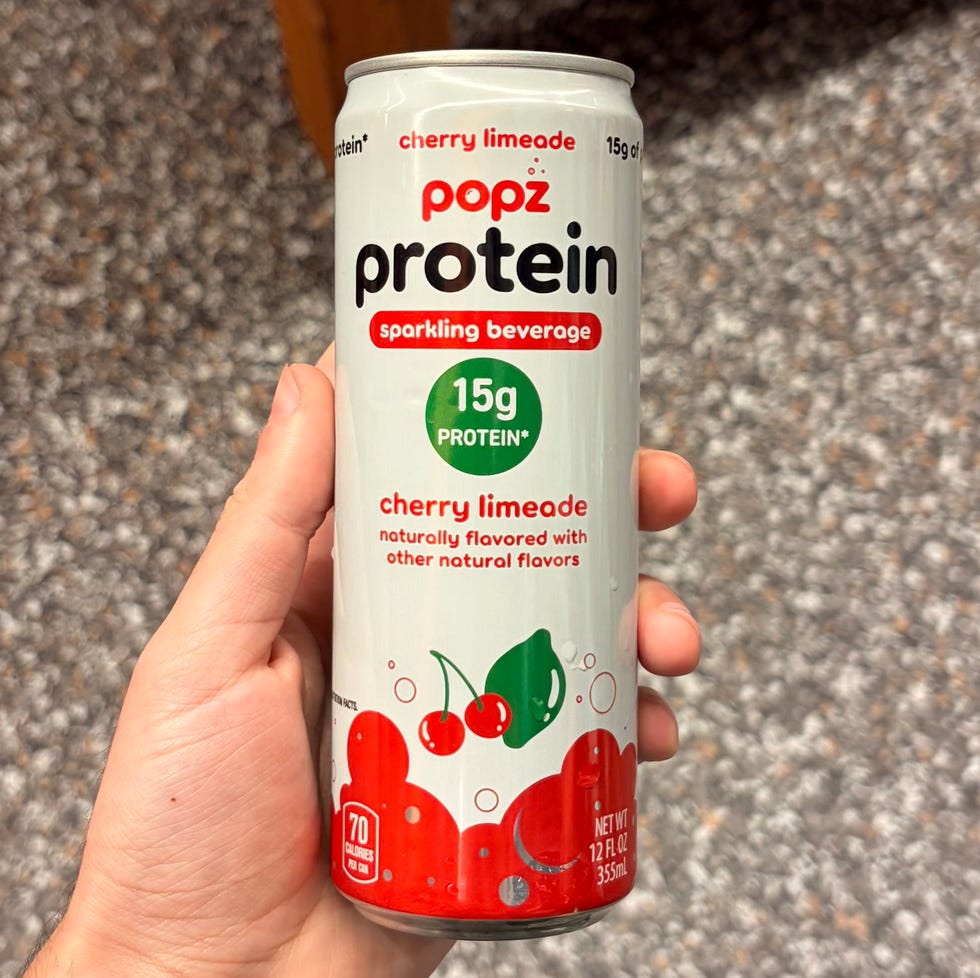 Hand holding a can of Popz Protein cherry limeade sparkling beverage.