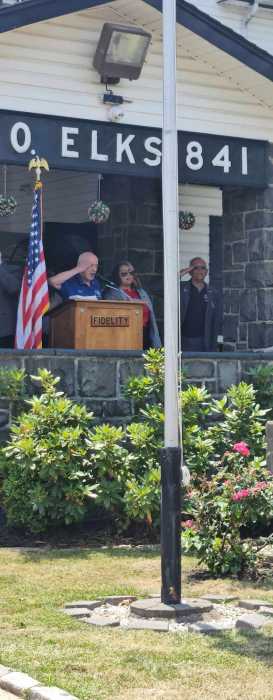 people speaking at a podium next to an American flag
