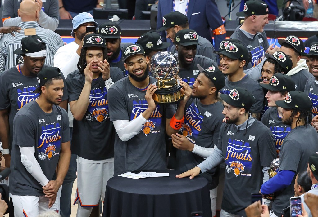 Knicks center Karl-Anthony Towns (32) and the New York Knicks hold up the Eastern Conference Finals trophy at the end the fourth quarter. 