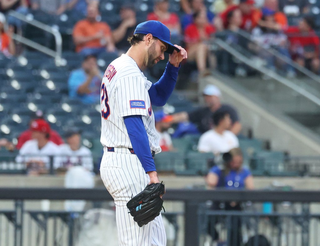New York Mets pitcher David Peterson adjusts his hat after giving up a 2-run home run.