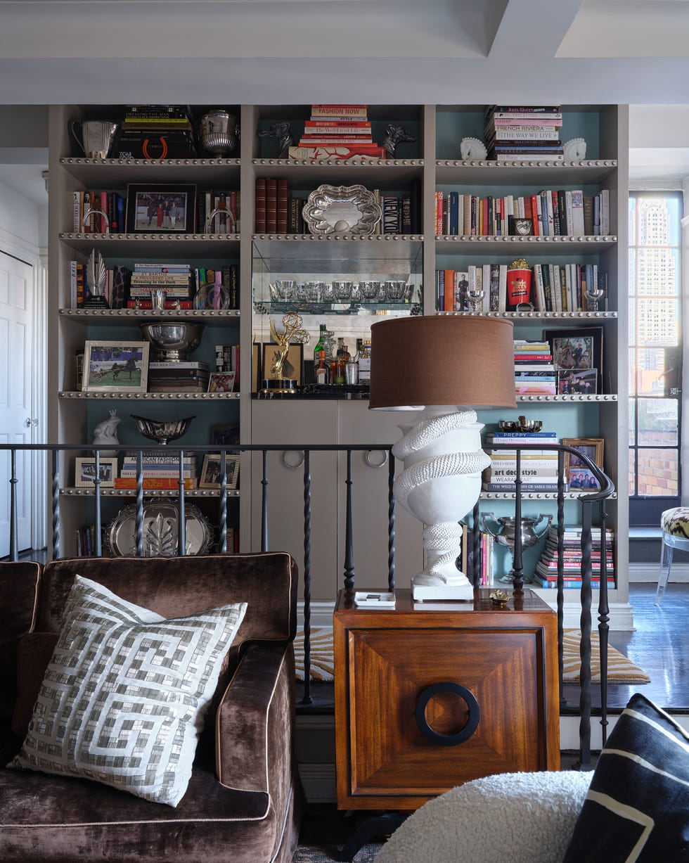living room section with the couch, a side table, and a bar and library behind it living room section with the couch, a side table, and a bar and library behind it
