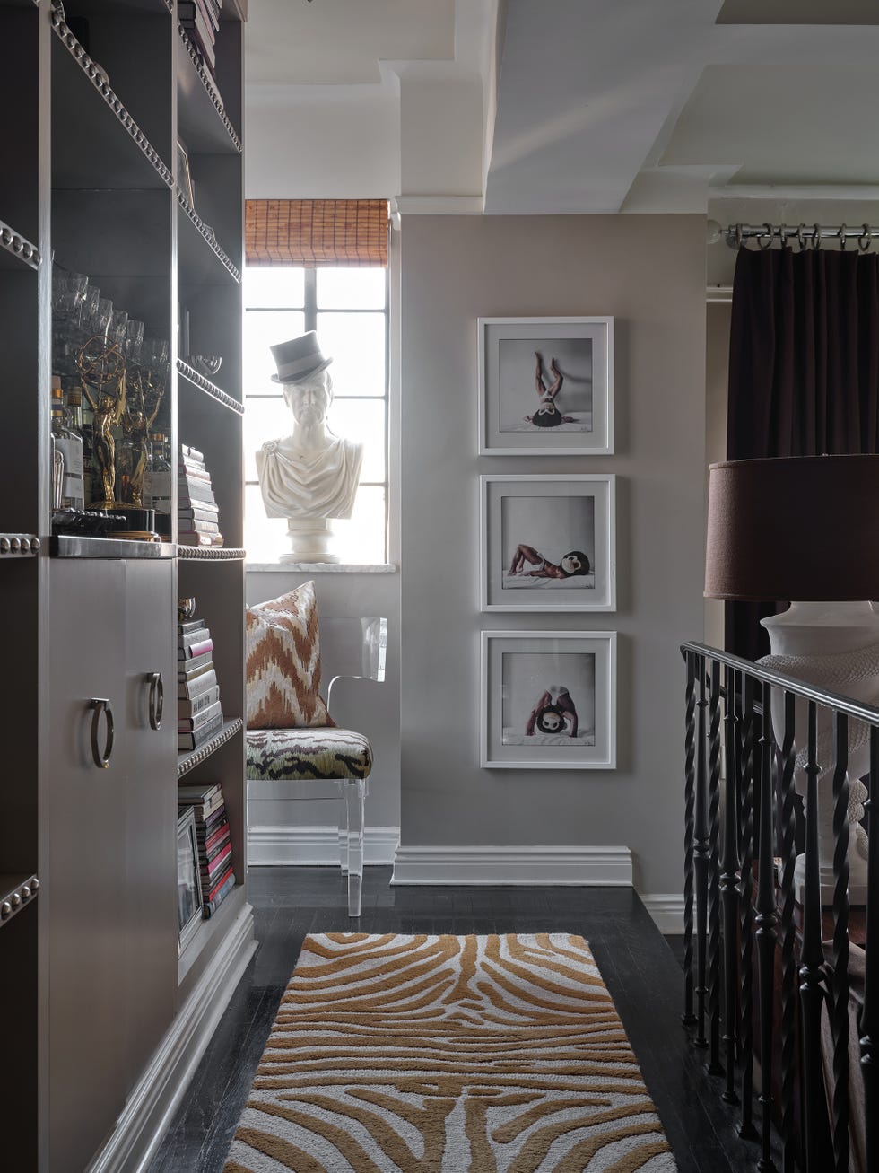 entryway with an animal print runner, art on the wall and cabinets on the side entryway with an animal print runner, art on the wall and cabinets on the side