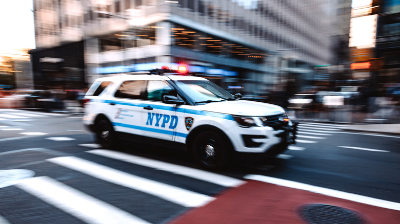 NYPD SUV crossing an intersection on zebra crossing in New York midtown district.