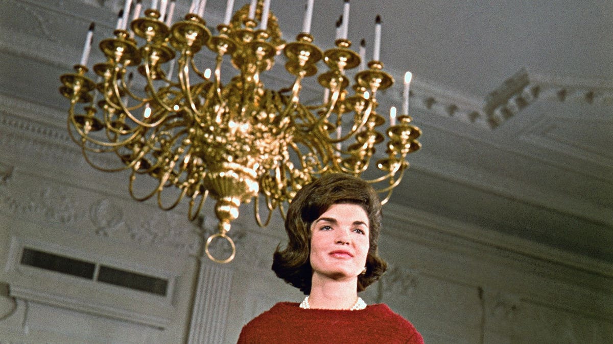 Mrs. John F. Kennedy walking inside the White House during a tour.