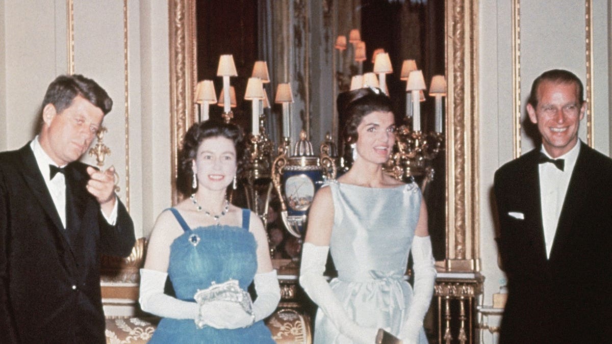 President John F. Kennedy and First Lady Jackie Kennedy standing with Queen Elizabeth II and Prince Philip.
