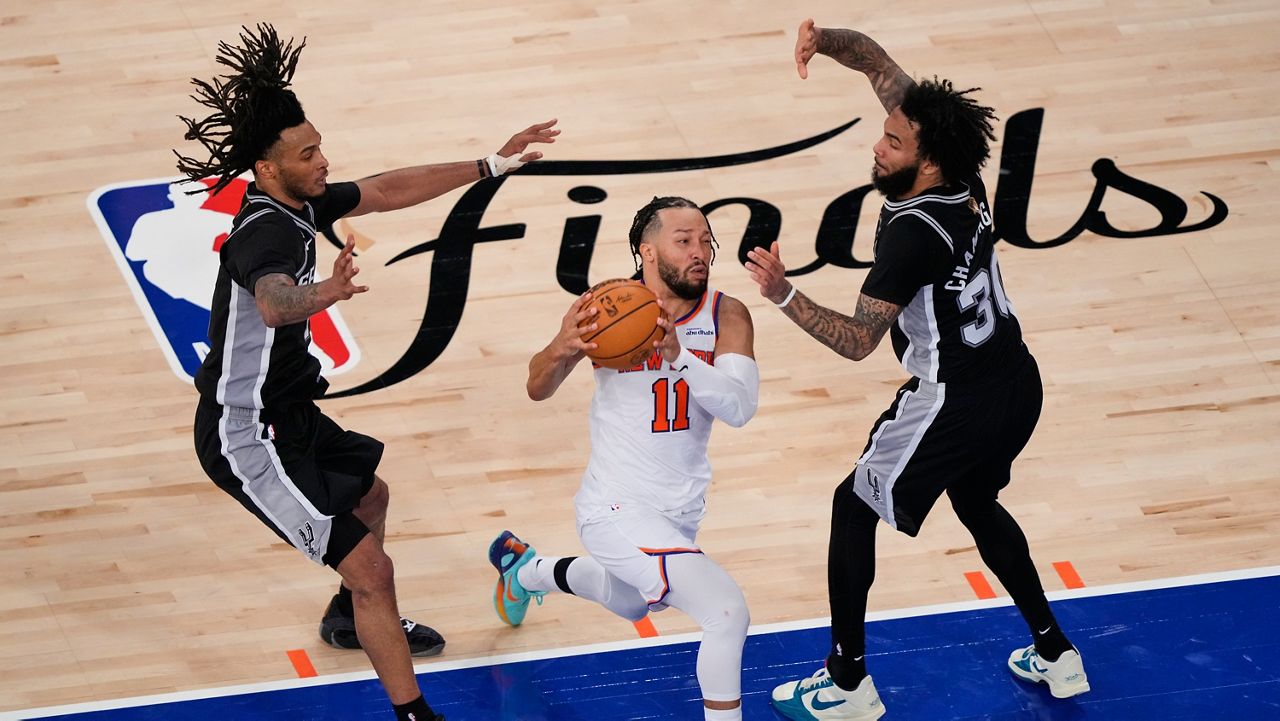 New York Knicks guard Jalen Brunson (11) drives past San Antonio Spurs defenders during the second half of Game 3 of the NBA Finals basketball series, Monday, June 8, 2026, in New York. (AP Photo/Yuki Iwamura)