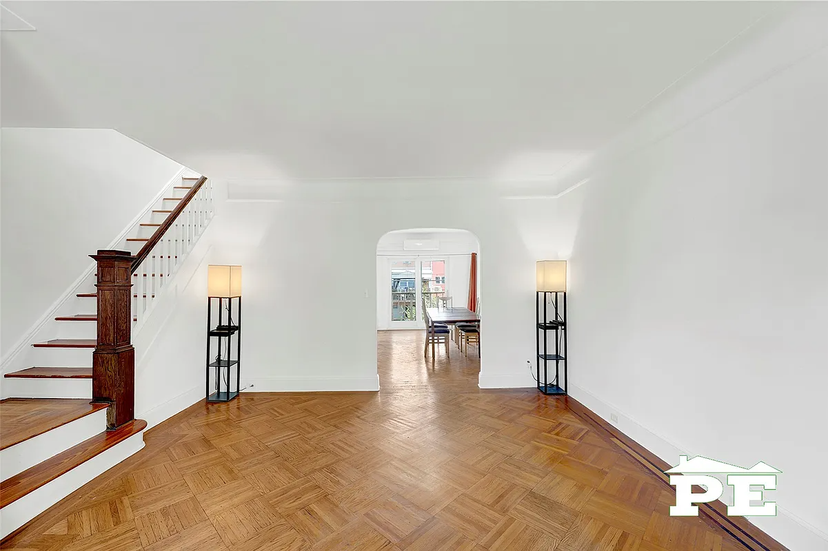 living room with wood floor, arched doorway