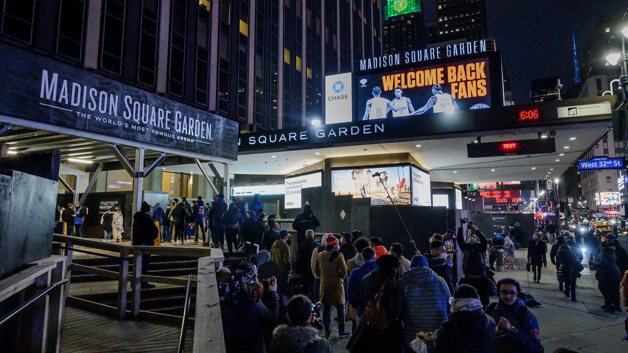 Fans line up outside Madison Square Garden for an NBA basketball game between the New York Knicks and the Golden State Warriors in New York, Tuesday, Feb. 23, 2021.