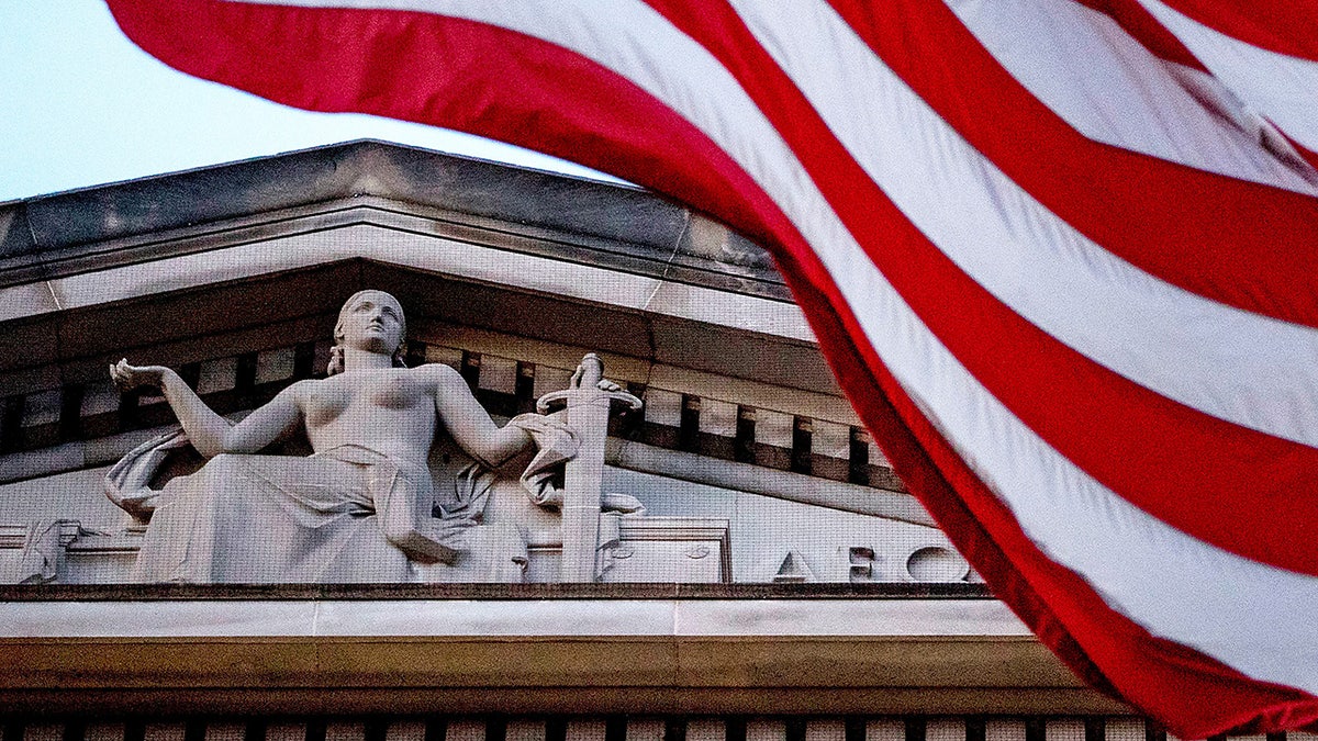 FILE - An American flag flies outside the Department of Justice in Washington, March 22, 2019.