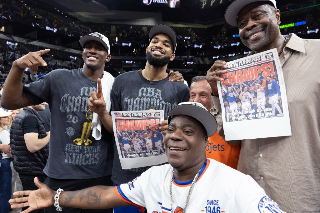 Karl-Anthony Towns (c.) and Patrick Ewing (r.) hold up the New York Post cover after winning the NBA championship on June 13, 2026.