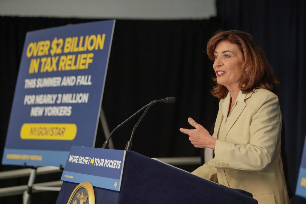 Governor Kathy Hochul speaking at a podium about New York's School Tax Relief (STAR) program, with a sign stating "Over $2 Billion in Tax Relief This Summer and Fall for Nearly 3 Million New Yorkers".