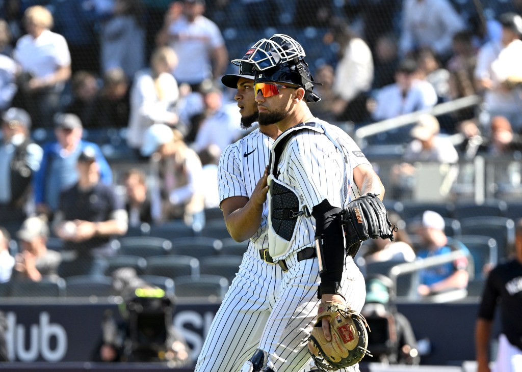 Yankees catcher J.C. Escarra and another player celebrate at Yankee Stadium.
