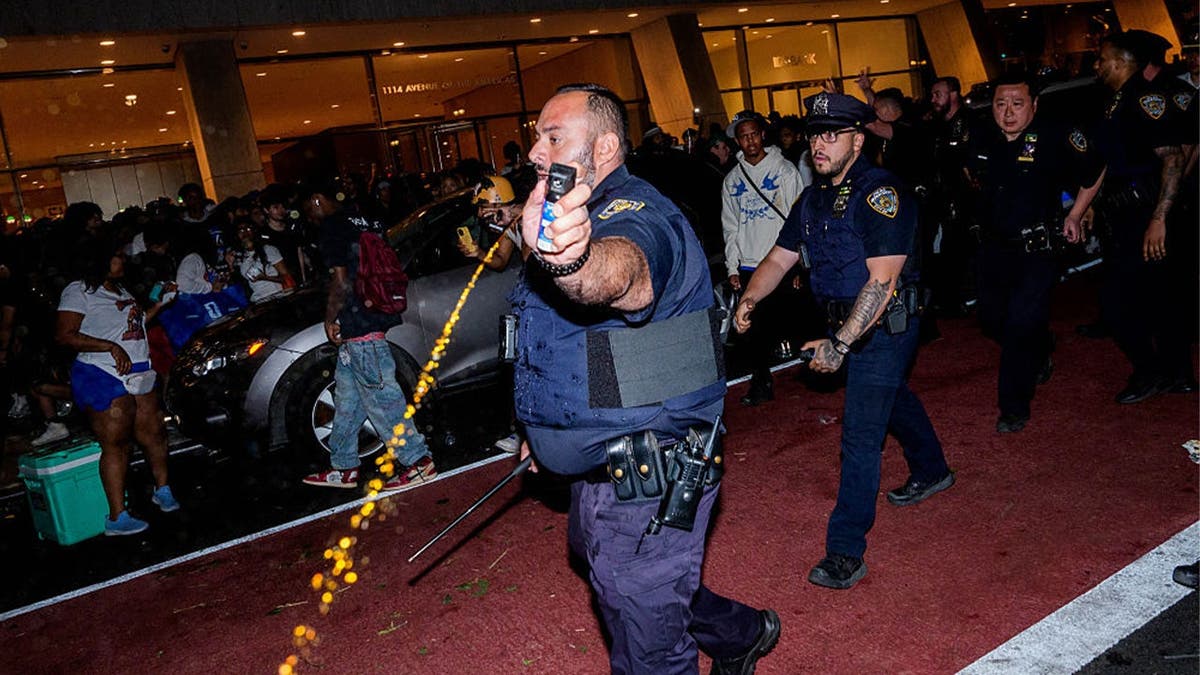 An NYPD officer uses pepper spray