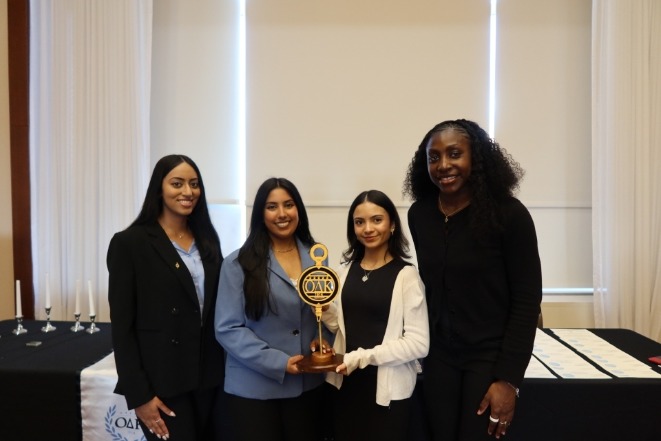 Four woman holding a trophy 