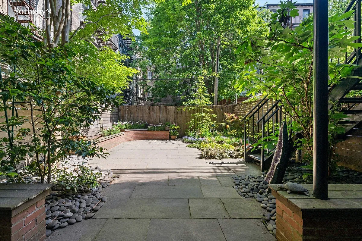 landscaped rear yard with raised planters, paved patio
