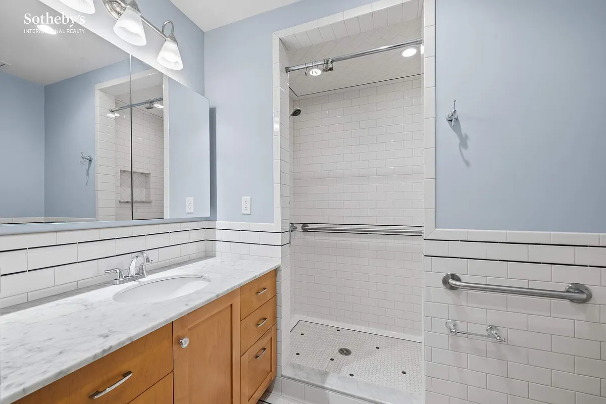 garden level bathroom with built-in shower, white subway tile with black accent tile