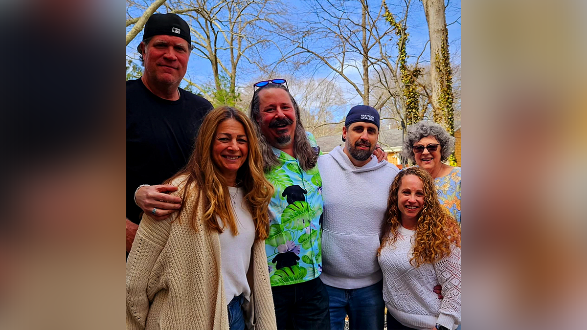 Paul Kueker standing with his family outdoors
