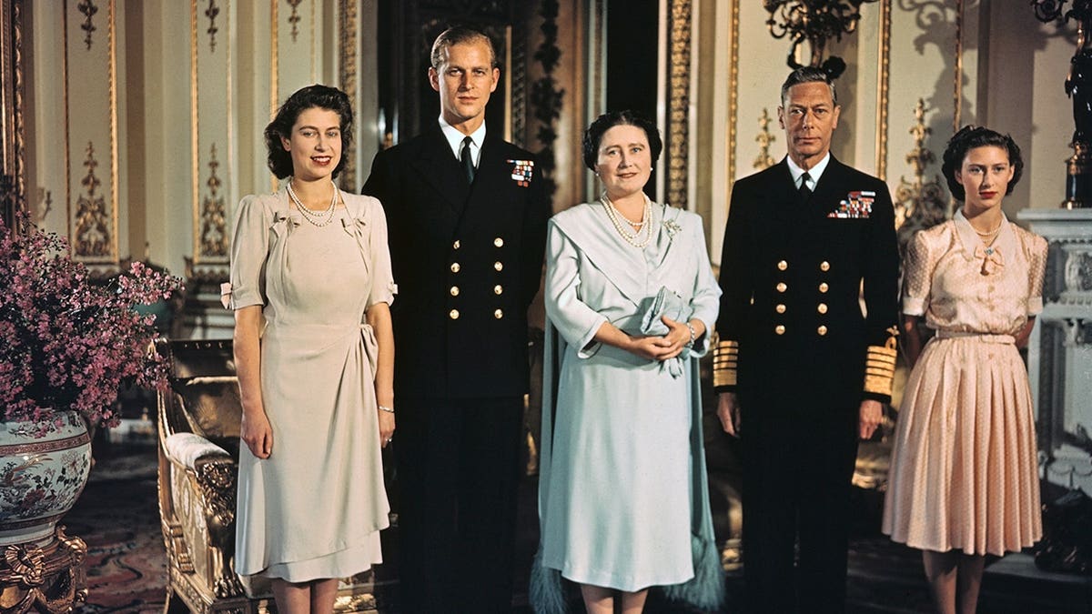 Princess Elizabeth standing with Lieutenant Philip Mountbatten, Queen Elizabeth, and King George VI in a family photograph