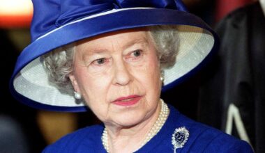 Britain's Queen Elizabeth II during a visit to Fitzalen High School wearing a royal blue suit with a matching wide-brim hat, a pearl necklace, and a sapphire and diamond brooch