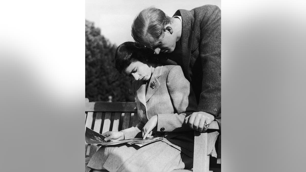 Princess Elizabeth and Philip Mountbatten looking at wedding photographs during honeymoon in Romsey Hampshire