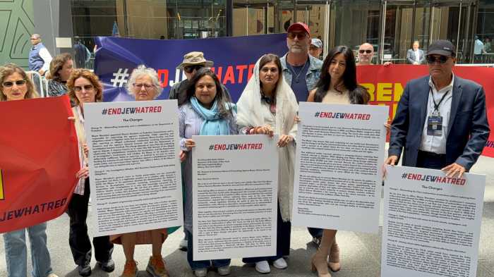 people outside a building holding large signs