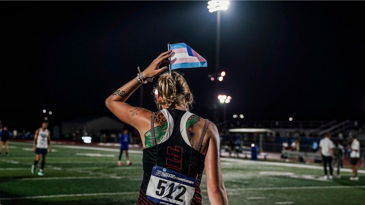 Sadie Schreiner putting a transgender flag in her hair at Doug Shaw Memorial Stadium