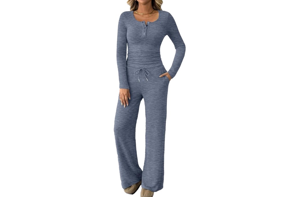 A woman wearing a blue long-sleeved shirt with buttons and matching blue pants with a drawstring and pockets.