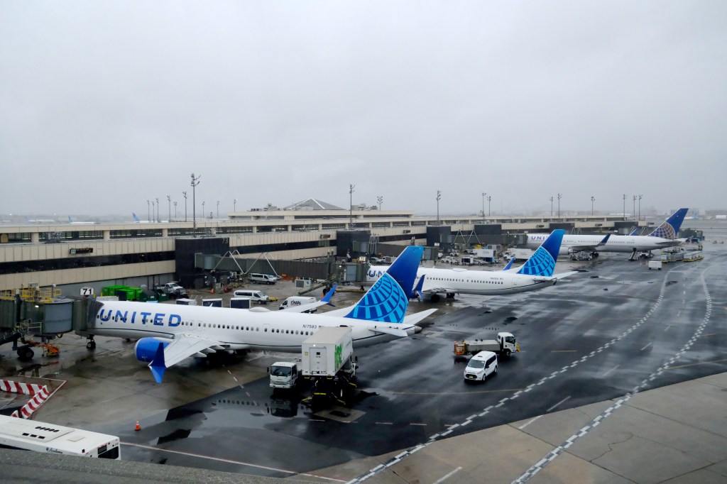 Three United Airlines airplanes parked at Newark Liberty International Airport's Terminal C.