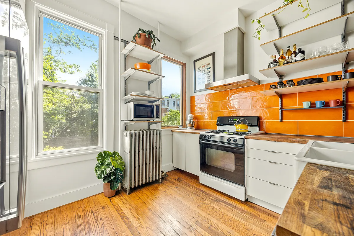 a kitchen with a bright orange backsplash