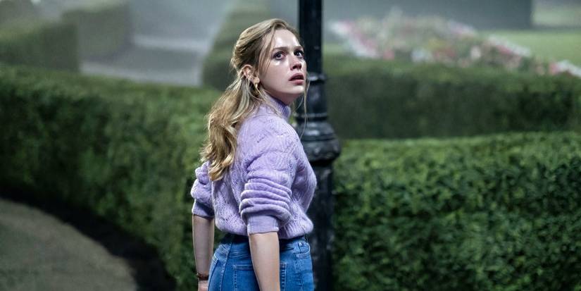 Dani standing outside and looking over her shoulder, her face tear-streaked, in The Haunting of Bly Manor