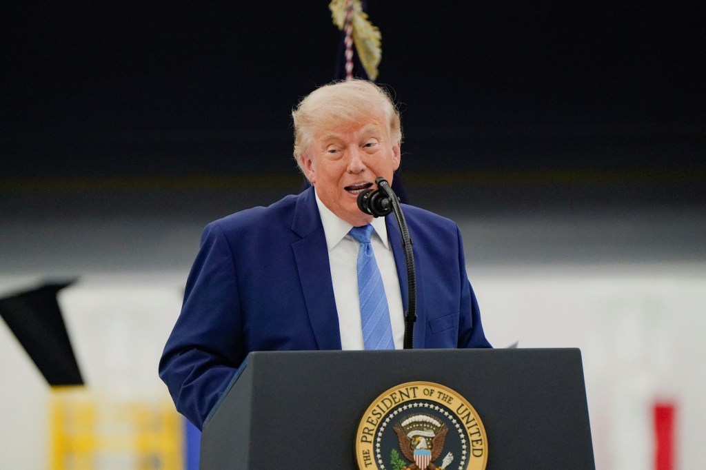 Donald Trump speaking at a podium with the Presidential Seal at Joint Base Andrews.