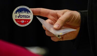 A poll worker prepares to give a voter a sticker at Madison Square Garden. (AP Photo/Mary Altaffer)