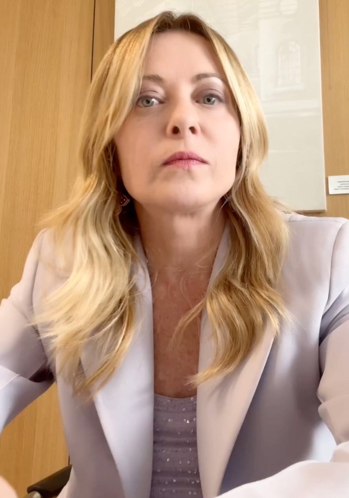 Giorgia Meloni, with long blonde hair, looking directly at the camera.