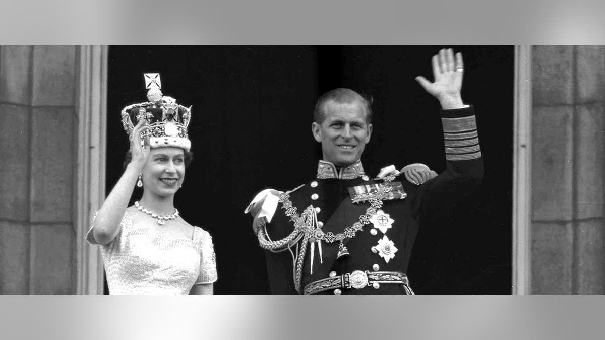 Queen Elizabeth II and Duke of Edinburgh waving from Buckingham Palace balcony