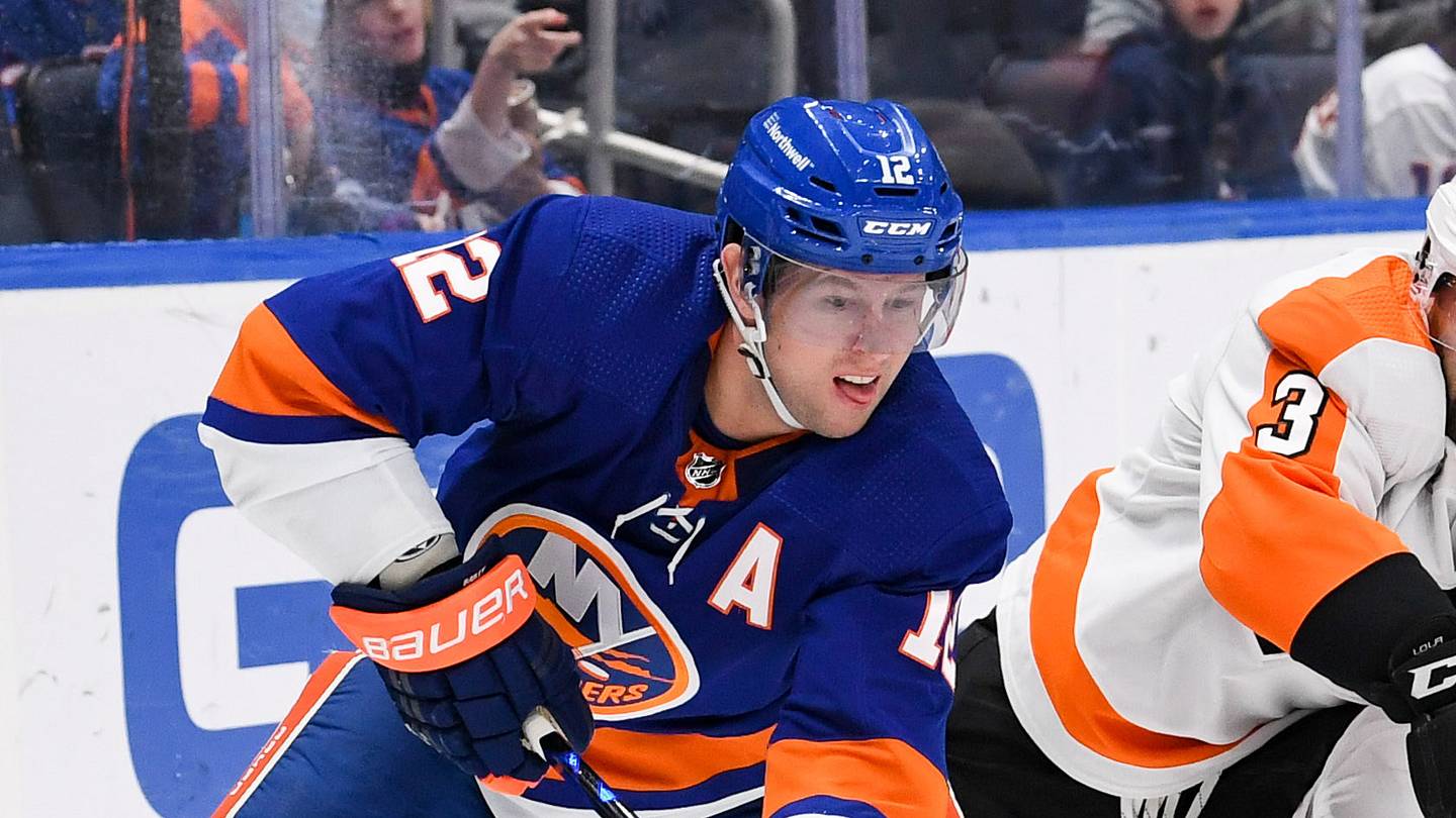 Jan 17, 2022; Elmont, New York, USA;  New York Islanders right wing Josh Bailey (12) looks to pass from behind the net defended by Philadelphia Flyers defenseman Keith Yandle (3) during the second period at UBS Arena. Mandatory Credit: Dennis Schneidler-USA TODAY Sports