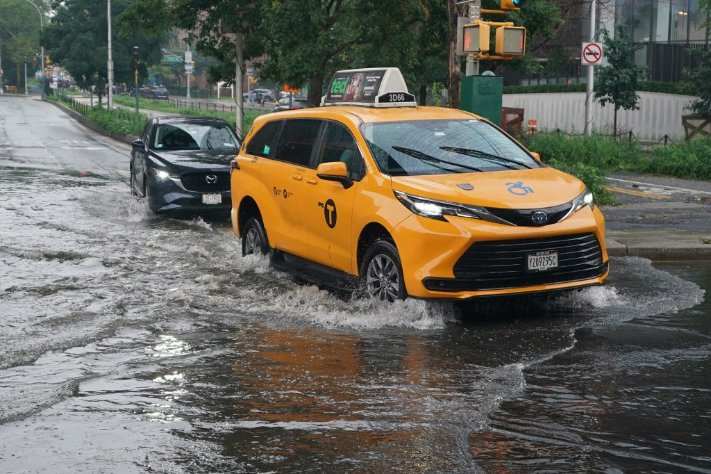 Vehicles pass through remains of earlier rain downpour