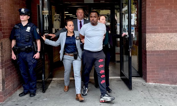 William Ferrer, 45, is pictured in police custody outside the 44th Precinct station house in the Bronx on Sunday, June 26, 2025 after being charged with murder in the shooting death of 12-year-old Jacob Freytes.