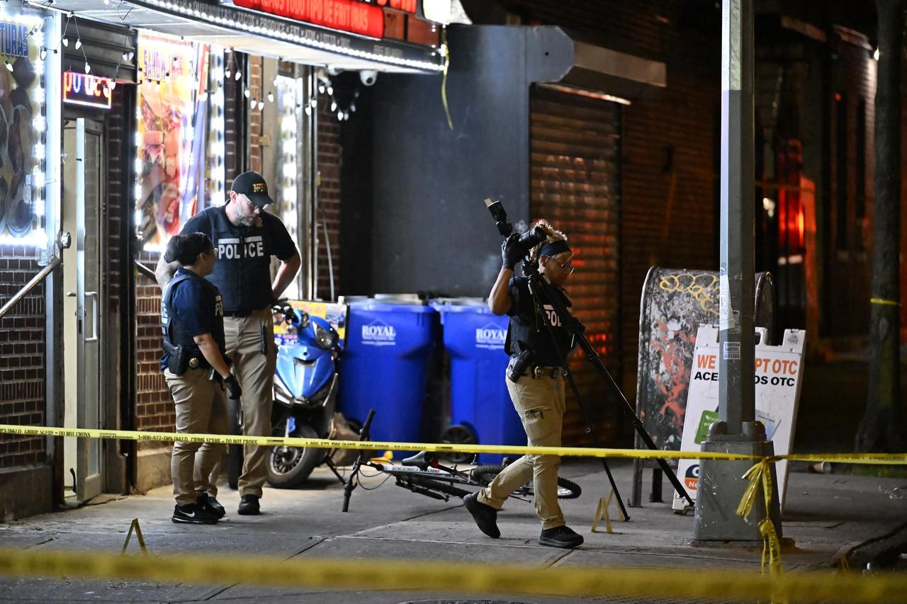 NYPD officers work the scene where a 12-year-old boy was killed and two men were injured in a shooting outside of a Supermarket and Deli at 104 Elliot Place in Bronx, New York, United States on July 25, 2026. (AA Photo)
