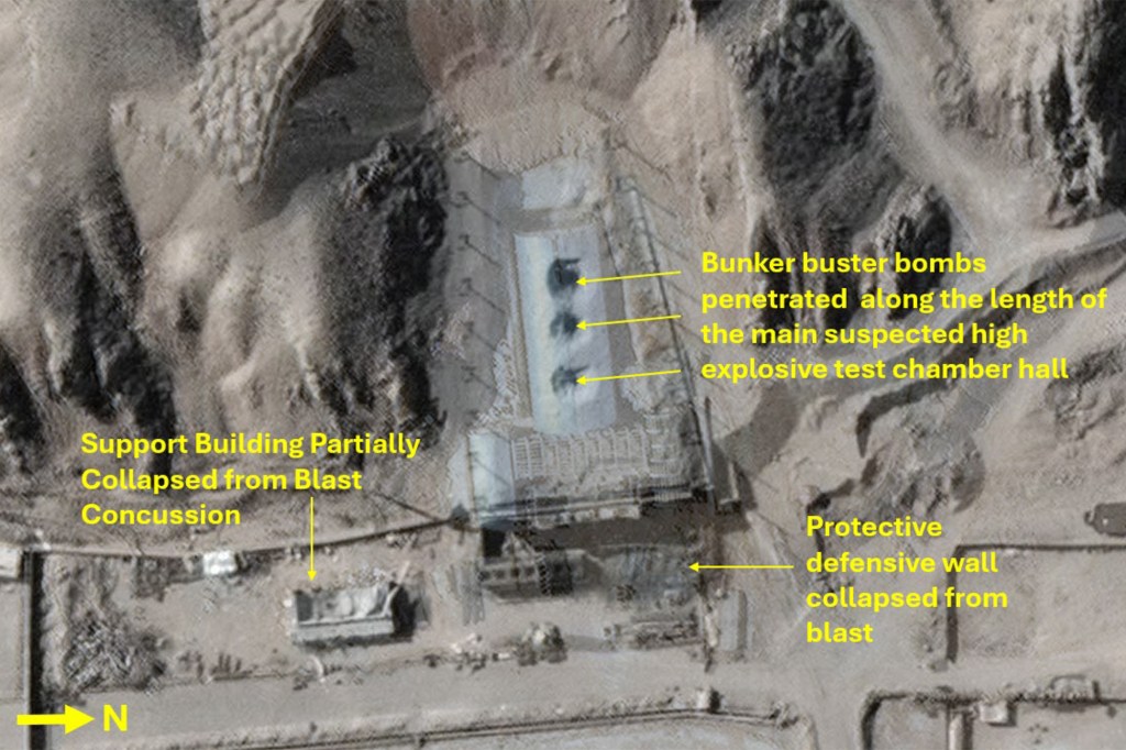 Aerial image of a suspected high explosive test chamber hall after being hit by bunker buster bombs, showing penetrations, a partially collapsed support building, and a collapsed protective defensive wall.