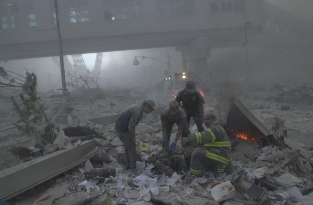 Rescue personnel and firefighters sit in rubble of the World Trade Center after it collapsed on September 11, 2001. (Todd Maisel / New York Daily News)firefighter ground zero