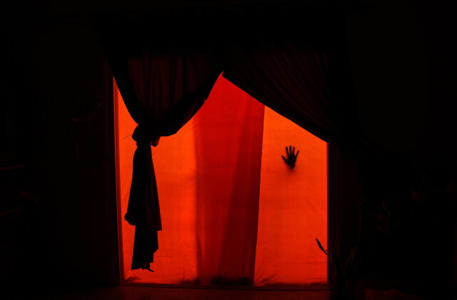 A woman's hand presses against a plastic sheet used to replace the shattered glass of a balcony door damaged in an Israeli strike in the southern port city of Tyre, Lebanon, Friday, June 19, 2026. (AP Photo/Hassan Ammar)