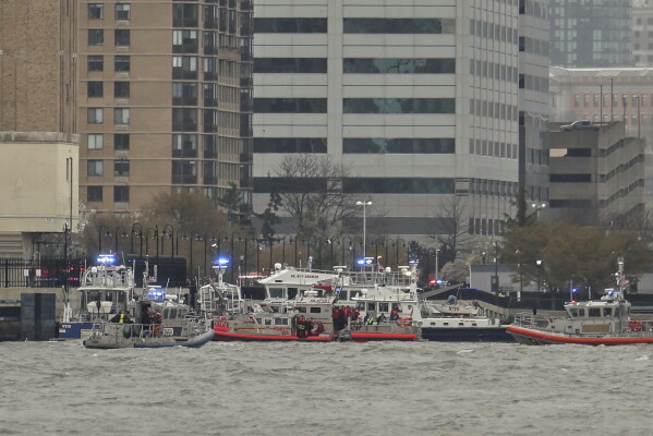 As seen from Pier 40 in New York, police and fire crews from New York and New Jersey respond to the scene Thursday, April 10, 2025, where a helicopter went down in the Hudson River between Manhattan and the New Jersey waterfront. (AP Photo/Yuki Iwamura)