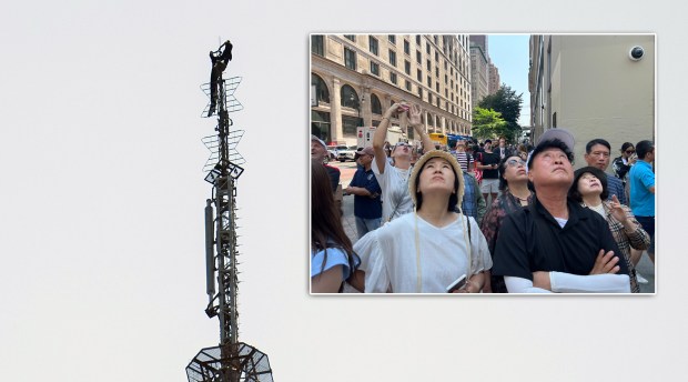 Angelina Nikolau and Ivan Kuznetsov are pictured on the top spire of the Empire State Building (main) as people watch from below (inset) on Wednesday.