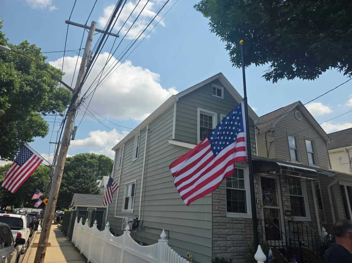An American flag is at half-staff in front of her family home on 96th Street and on neighboring homes in Ozone Park.

